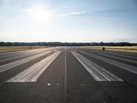 a runway that has been painted white and black, with the sun shining on top