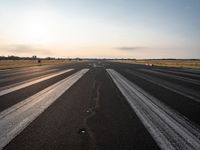 the sun is shining brightly across an airport runway with airplanes and people walking on the pavement