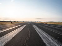 the sun is shining brightly across an airport runway with airplanes and people walking on the pavement