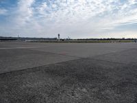 a couple of people are walking towards an airplane in the middle of a runway at an airport