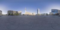 the image shows an empty city square and the sky is clear and blue with buildings