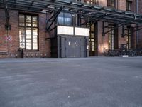 the view down the street toward an empty parking lot with bicycles parked and the entrance to the building