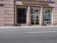 a building with three windows and two bikes parked on the street outside of it and a sign reading wickersho