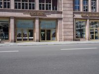 a building with three windows and two bikes parked on the street outside of it and a sign reading wickersho