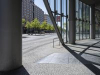 a corner with a manhole in the middle and a building out the window with trees outside