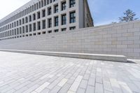 the walkway is paved and bricked with bricks around it, and people walk down the sidewalk