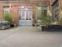 a large planter on the sidewalk outside of a building with a big open door