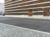 the road is made of stone and brick in front of a building with a brown facade