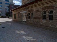 brick road with an outdoor area and a bench at the end of the walkway next to it