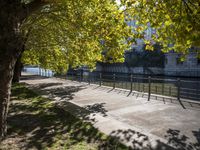 a bridge spans over the river next to a row of buildings and some trees on the sidewalk