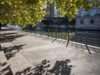 a bridge spans over the river next to a row of buildings and some trees on the sidewalk