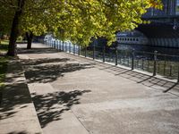 a bridge spans over the river next to a row of buildings and some trees on the sidewalk