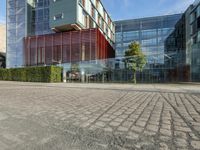 a building with a parking lot next to it and trees in front of the buildings