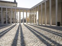 an empty courtyard is shown with sun shining through the pillars and columns at dusk or dusk