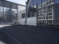 the building is next to the large glass windows in the middle of the area is an empty parking lot