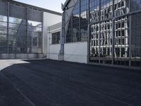 the building is next to the large glass windows in the middle of the area is an empty parking lot