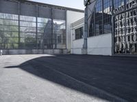 the building is next to the large glass windows in the middle of the area is an empty parking lot