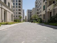 one long and narrow driveway in the middle of an empty city street with many buildings in the background