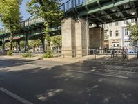 a bicycle is parked under the bridge and a person riding a bike in the street