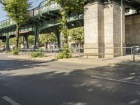 a bicycle is parked under the bridge and a person riding a bike in the street