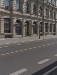 the empty street near some buildings with street lamps on both sides of it and yellow lines