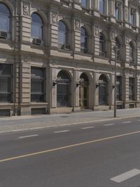 the empty street near some buildings with street lamps on both sides of it and yellow lines