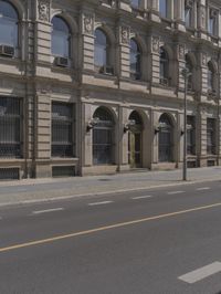 the empty street near some buildings with street lamps on both sides of it and yellow lines