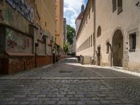 an empty cobblestone street with no people in the middle of it and buildings all around