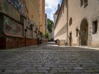 an empty cobblestone street with no people in the middle of it and buildings all around