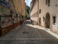 an empty cobblestone street with no people in the middle of it and buildings all around