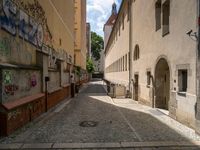 an empty cobblestone street with no people in the middle of it and buildings all around