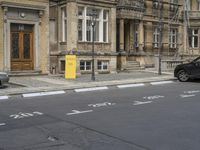 an empty building with signs on the street and people on bikes in traffic passing by