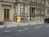 an empty building with signs on the street and people on bikes in traffic passing by