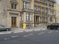 an empty building with signs on the street and people on bikes in traffic passing by