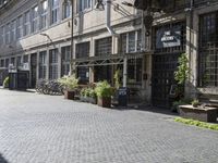 an old, open brick - lined street in front of building with several empty benches