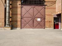 there is an outside area with a building and two brick walls and a red door