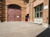 there is an outside area with a building and two brick walls and a red door