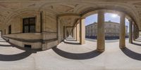 a reflection of an exterior with columns and arches in a panoramic style in an oval mirror