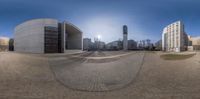 two fish - eye view of an outside area with several buildings and a sidewalk to the right of the lens