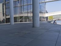 an empty building with a man sitting by it on the ground with his feet up in a fountain