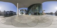 360 - view of a very unusual building by the water with some buildings on it