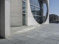 a person riding a skate board near a building with a circular window in the center