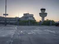 some cars are parked at an air traffic control tower with smoke coming from the air