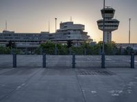 some cars are parked at an air traffic control tower with smoke coming from the air