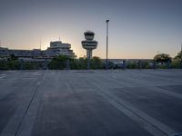 some cars are parked at an air traffic control tower with smoke coming from the air