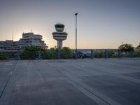 some cars are parked at an air traffic control tower with smoke coming from the air