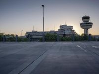some cars are parked at an air traffic control tower with smoke coming from the air