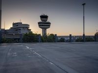 some cars are parked at an air traffic control tower with smoke coming from the air