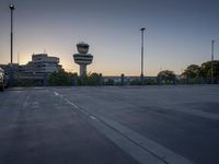 some cars are parked at an air traffic control tower with smoke coming from the air