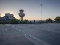 some cars are parked at an air traffic control tower with smoke coming from the air